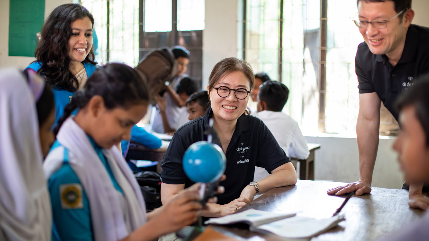 Photo of a Cl&eacute; de Peau Beaut&eacute; representative engaging with students during a classroom visit in บังกลาเทศ.