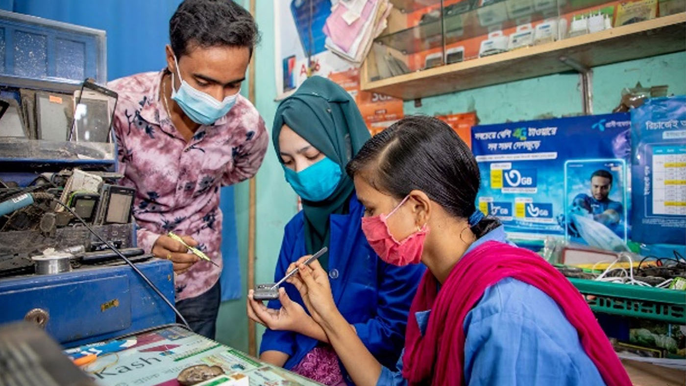 Photo of two girls repairing electronic devices.