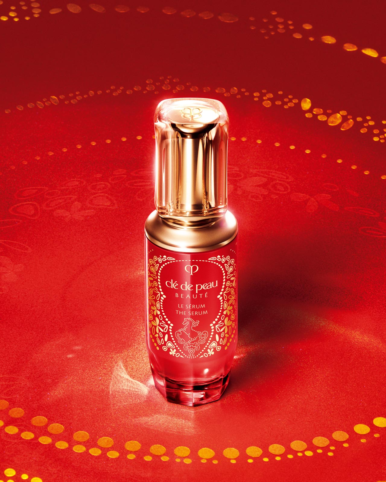 Photo of Cl&eacute; de Peau Beaut&eacute;'s limited-edition THE SERUM for Lunar New Year, featuring a red bottle with a gold horse motif and a gold cap.