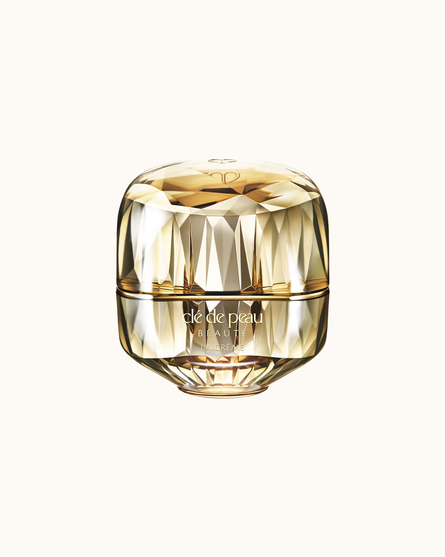 Photo of a jewel-cut, translucent gold container. The sparkling form reflects light, and the front features the brand logo and the text &ldquo;LA CR&Egrave;ME&rdquo; (current packaging).