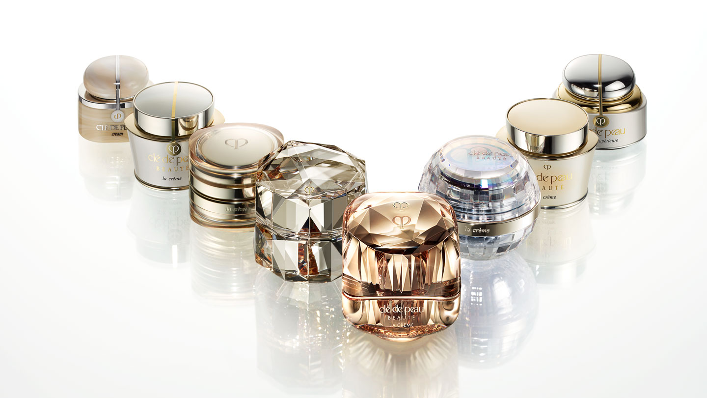 Photo of the La Cr&egrave;me history lineup, showing each generation of the product elegantly arranged in an arc.