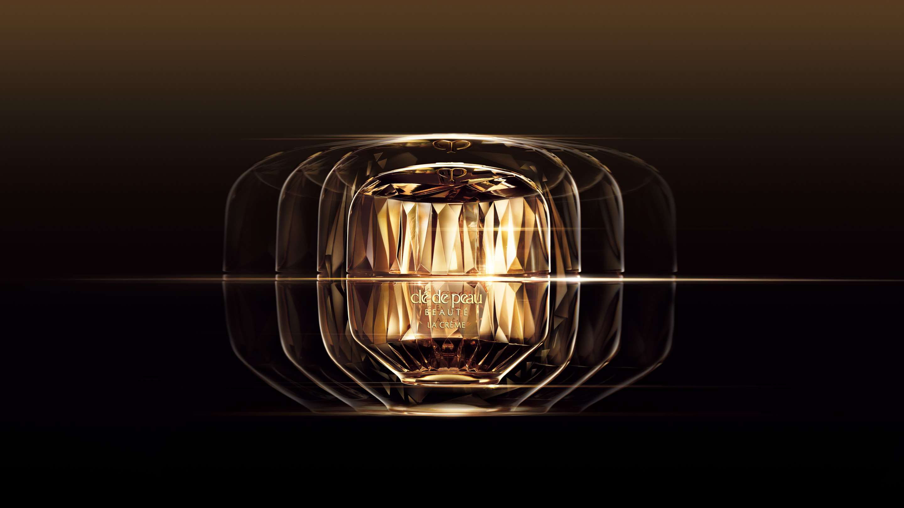 Photo of La Cr&egrave;me, captured in a cinematic music video style visual with layered reflections and golden light radiating from the faceted jar against a dark gradient background.
