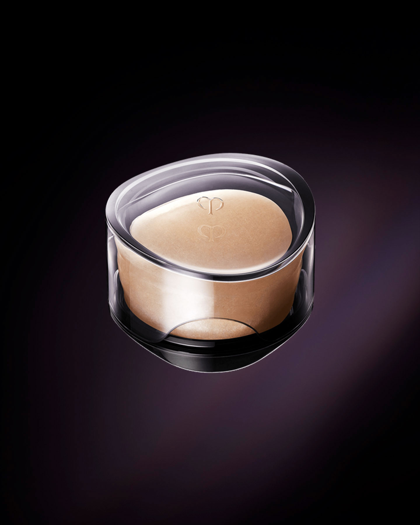 Photo of the luxurious Cl&eacute; de Peau Beaut&eacute; SYNACTIF SOAP. An elegant, round purifying soap in a warm peach hue is presented within a sophisticated, clear case. The brand's logo is delicately embossed on the surface of the soap and on the lid of its case.