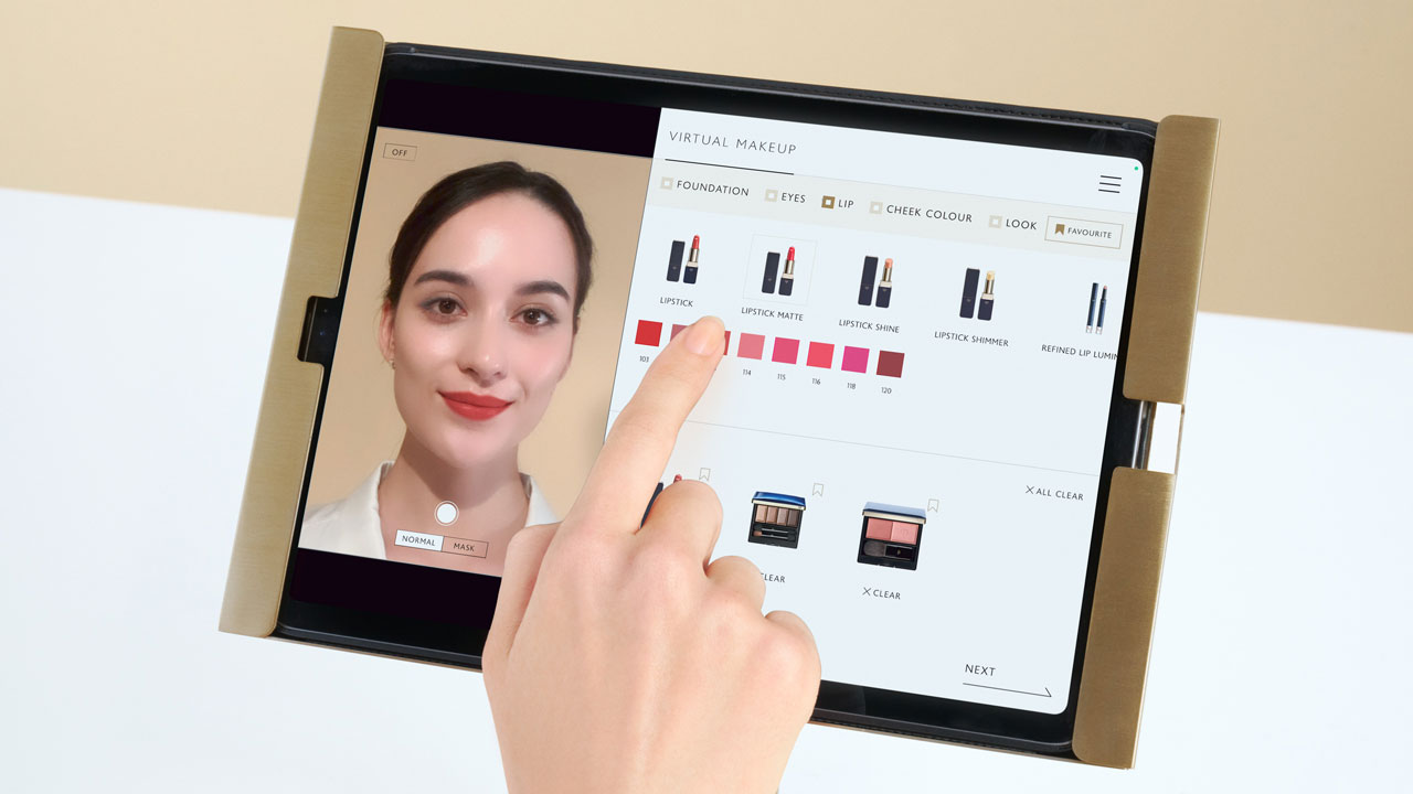 Photo of a woman selecting a lip color on a tablet using a virtual makeup application.