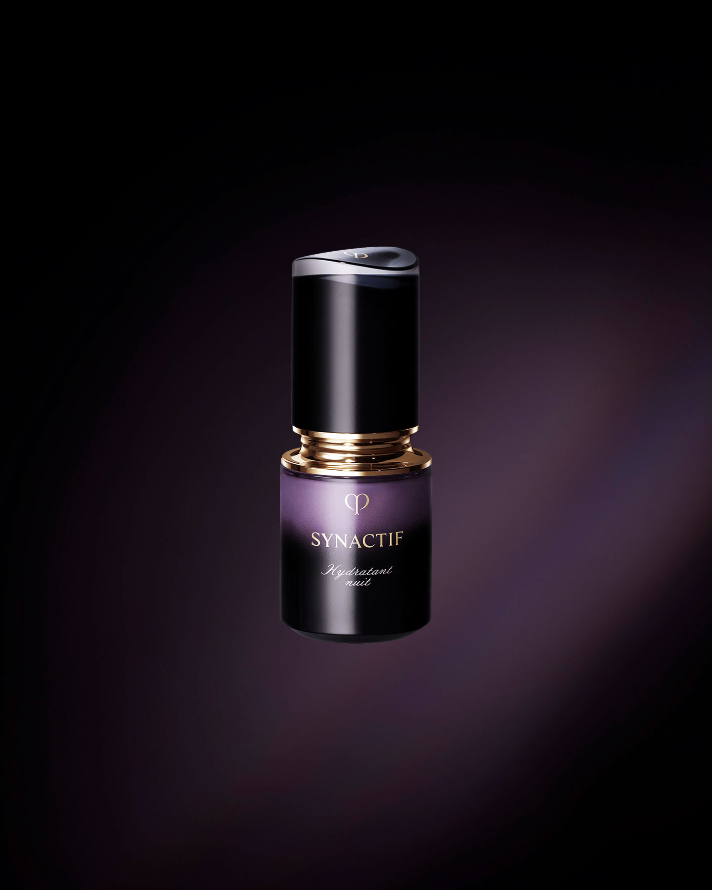 Photo of the Cl&eacute; de Peau Beaut&eacute; SYNACTIF NIGHTTIME MOISTURIZER. It is presented in a compact cylindrical bottle with a black-to-purple gradient. There is a gold accent between the cap and the body, and the 'SYNACTIF' logo is elegantly displayed on the front.