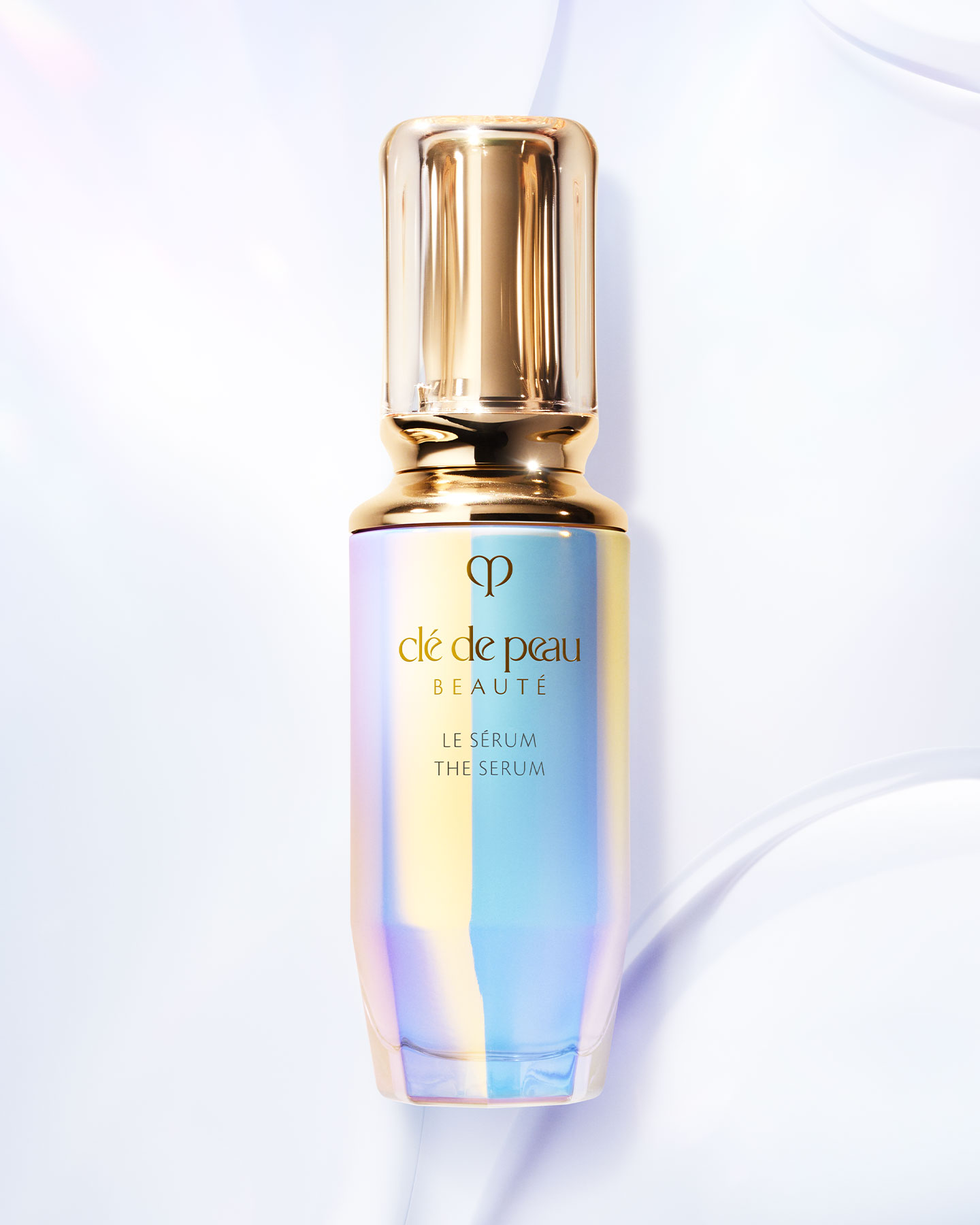 Photo of LE S&Eacute;RUM bottle with an iridescent finish and a rounded, translucent gold cap.