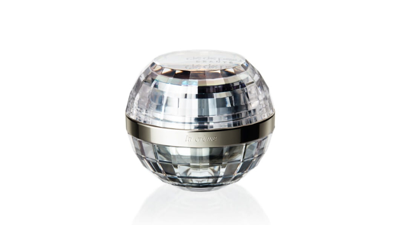 Photo of a spherical design with mirrorball-like cuts. A silver band around the center is engraved with the text &ldquo;la cr&egrave;me&rdquo; (former packaging).