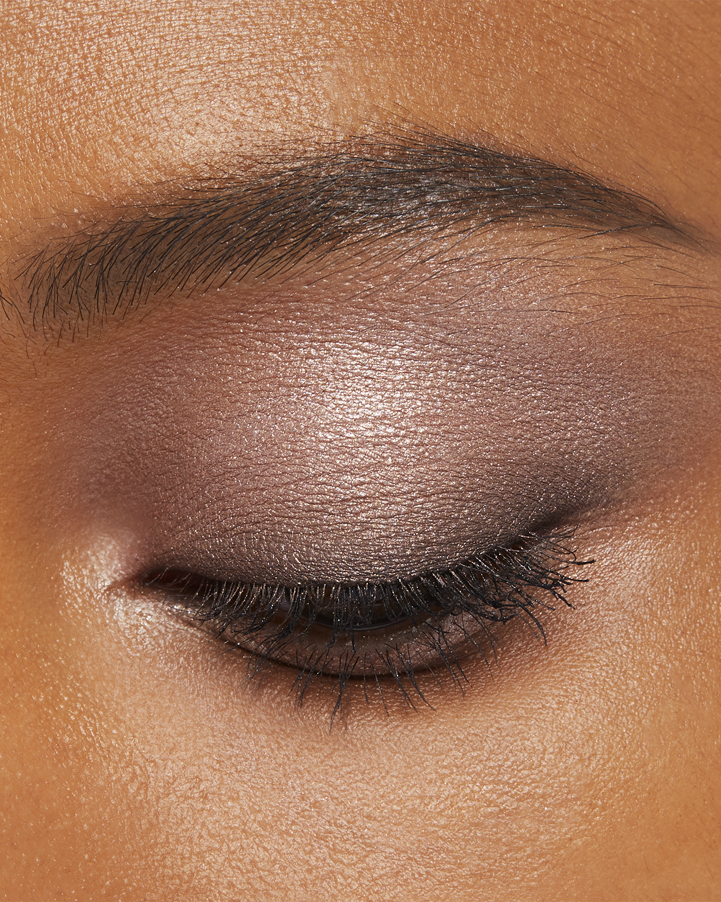 Photo of a deep skin tone model wearing EYE COLOR QUAD in 1-Sand Dunet on the eyes.