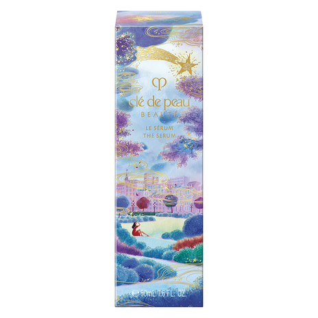 Photo of the 26 AW Holiday Collection limited-edition THE SERUM outer box. The package features an illustration of a woman looking up at a town under a starry night sky with purple clouds, decorated with a large gold shooting star at the top.