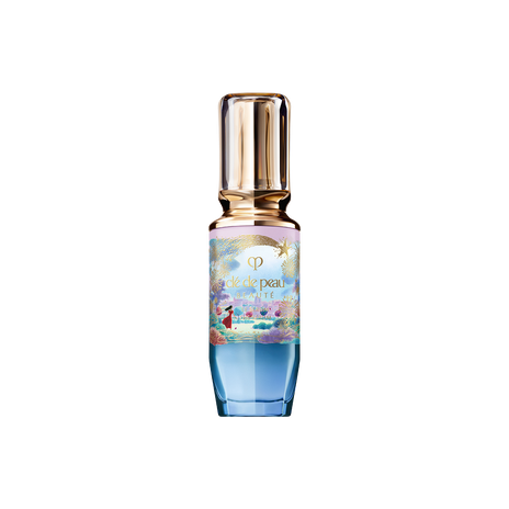 Photo of the 26 AW Holiday Collection limited-edition THE SERUM. The glass bottle features a blue and pink pastel gradient decorated with a gold shooting star and scenery illustration, topped with a clear gold cap.