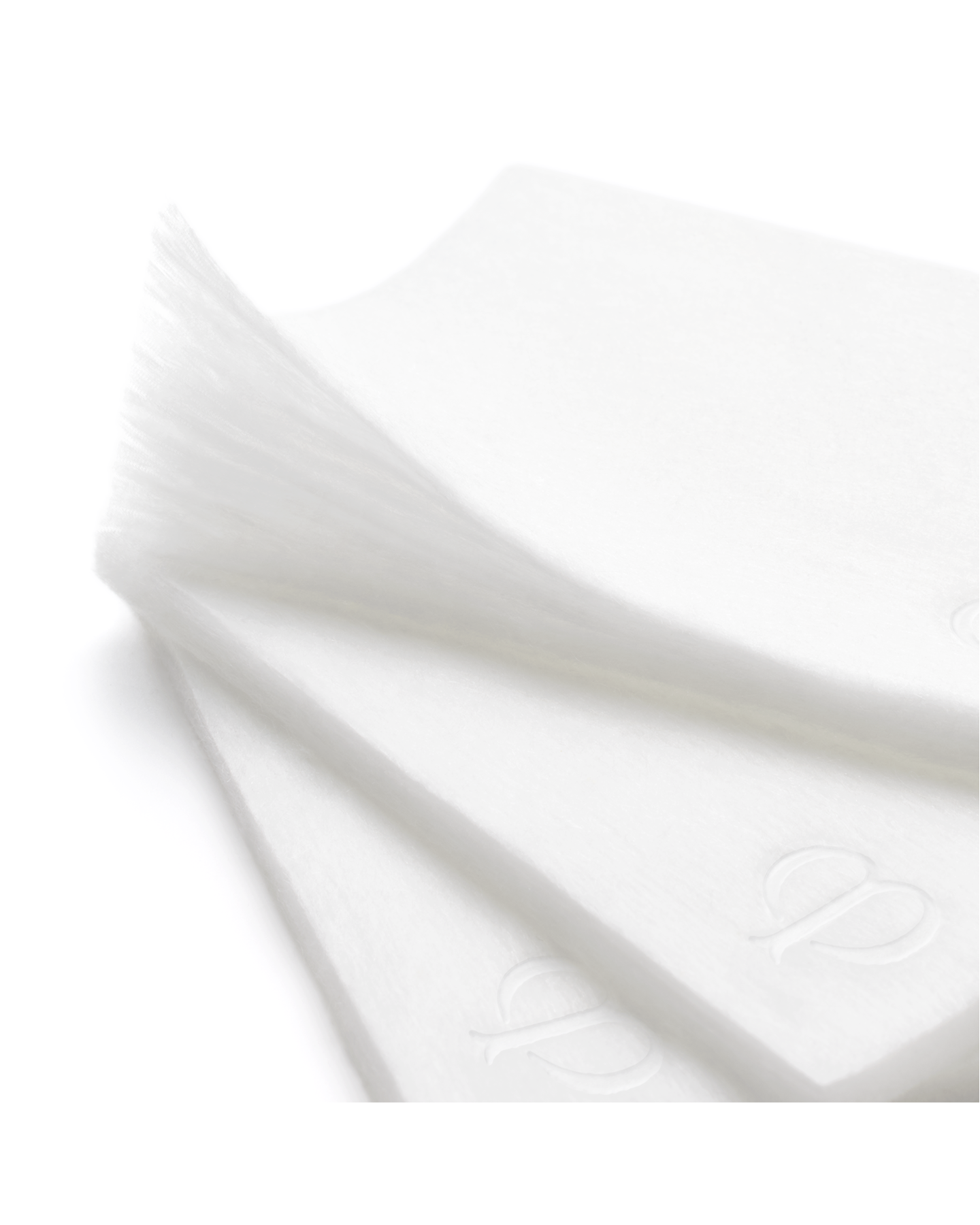 Close-up photo of COTTON pads embossed with the brand logo.