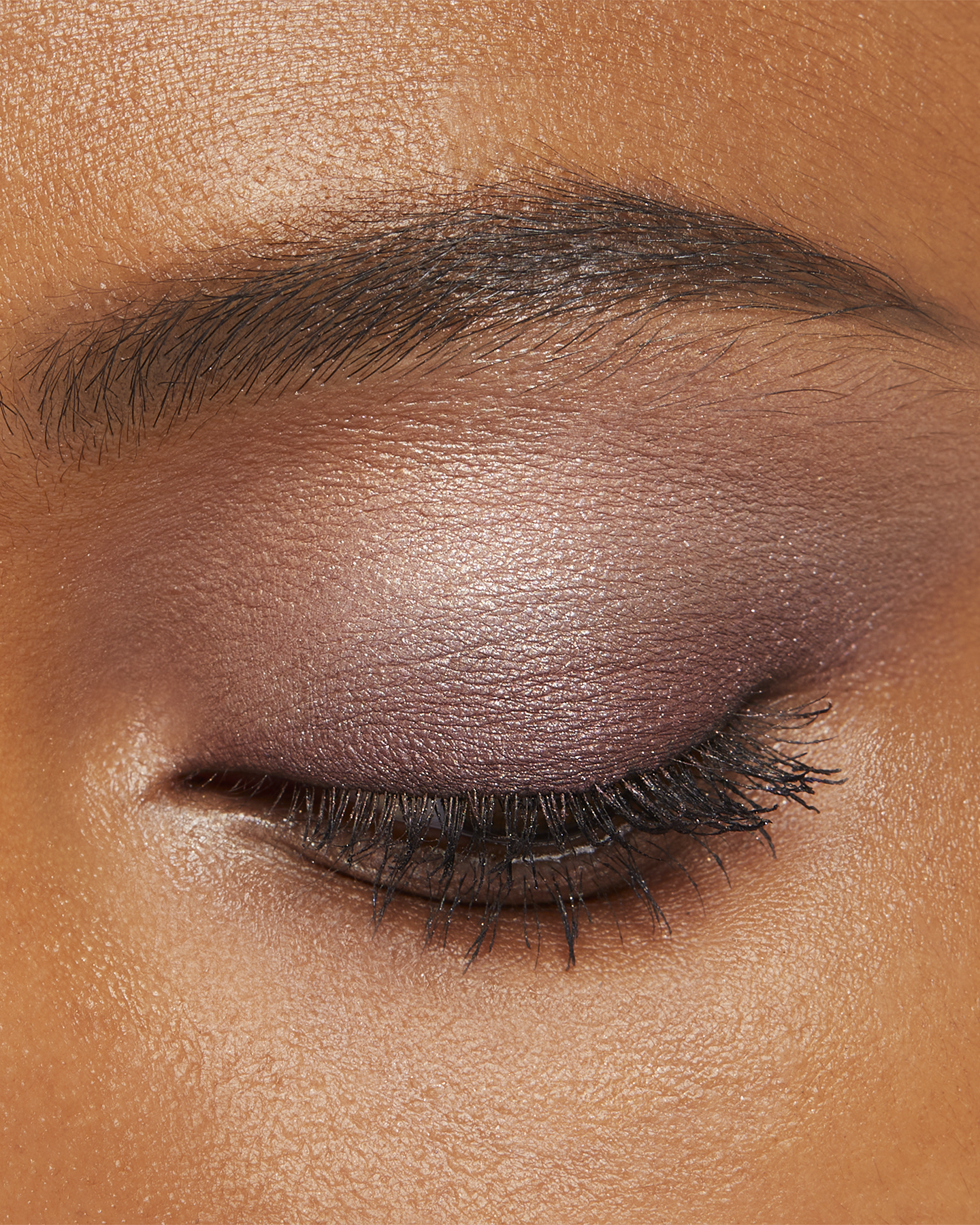 Photo of a deep skin tone model wearing EYE COLOR QUAD in 3-Sundried Driftwood on the eyes.