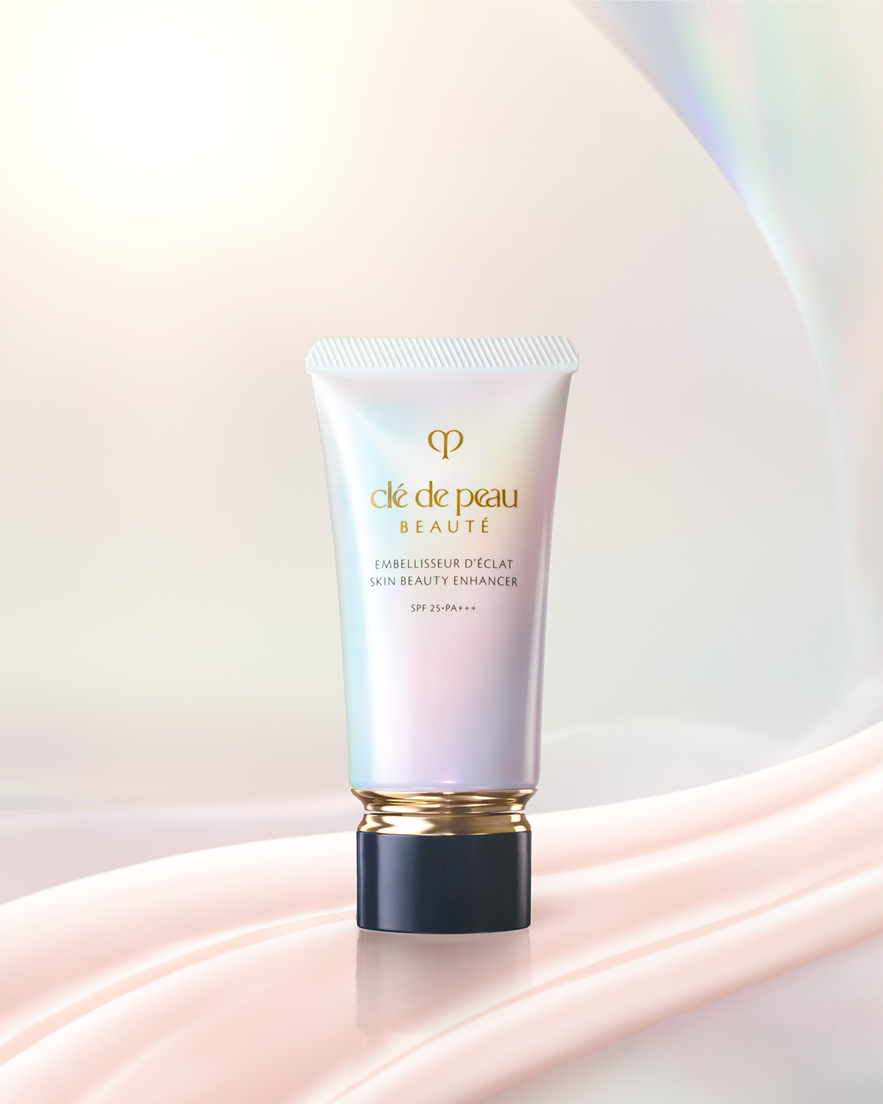 Photo of SKIN BEAUTY ENHANCER in a pearlescent gradient tube with a gold band and black cap, shown with two pale pink product swatches.
Photo of SKIN BEAUTY ENHANCER in a pearlescent gradient tube with a gold band and a blue-black cap.
