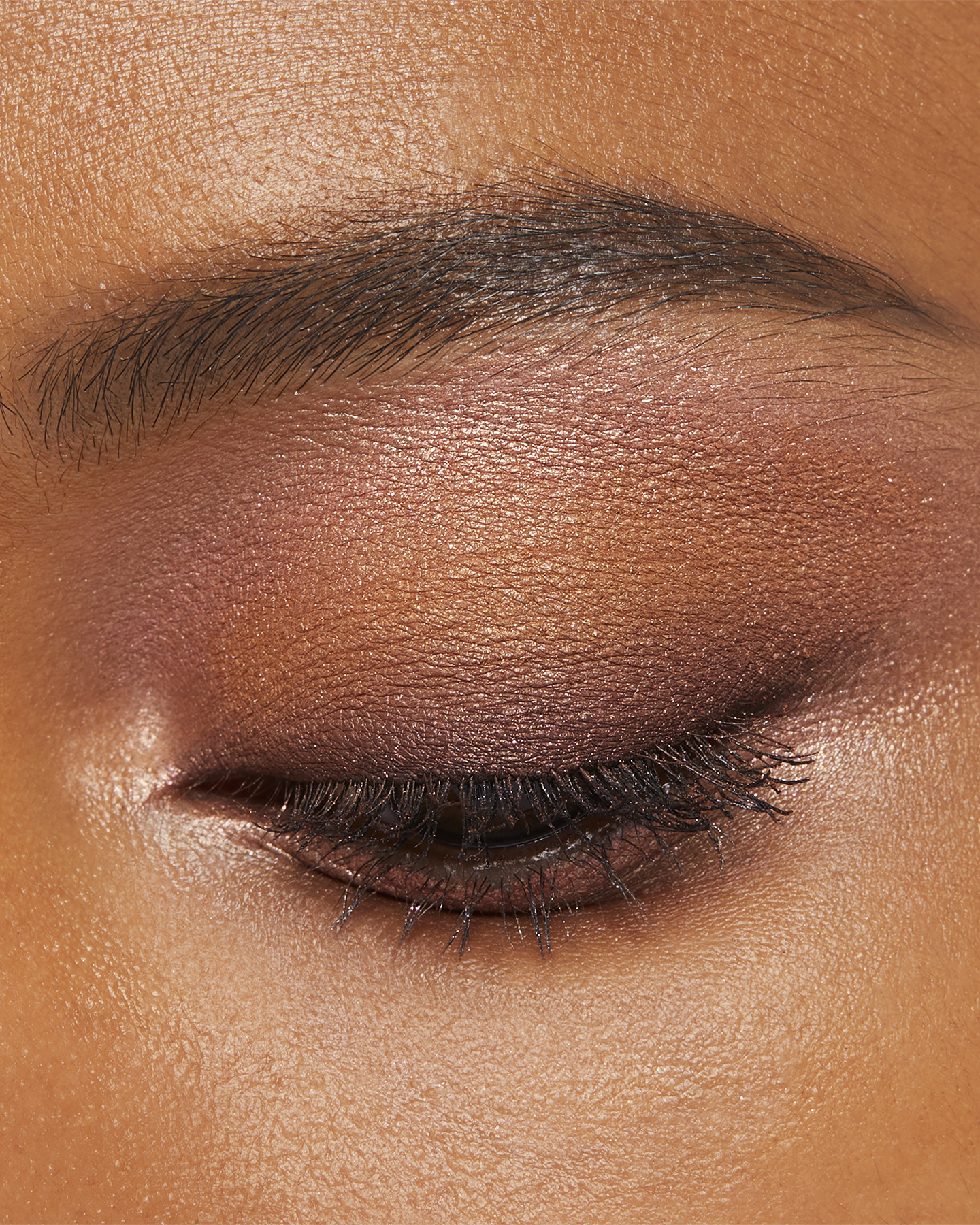 Photo of a deep skin tone model wearing EYE COLOR QUAD in 7-Starlight Splendort on the eyes.