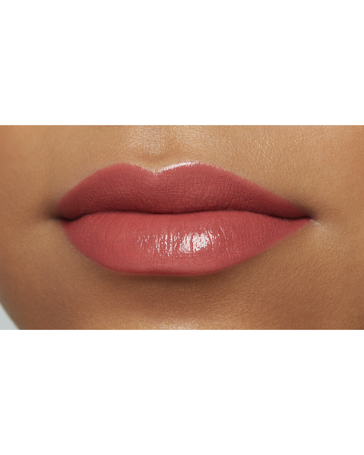 Photo of the lips of a model with a deep skin tone wearing "LIPSTICK" in the shade Positively Playful.