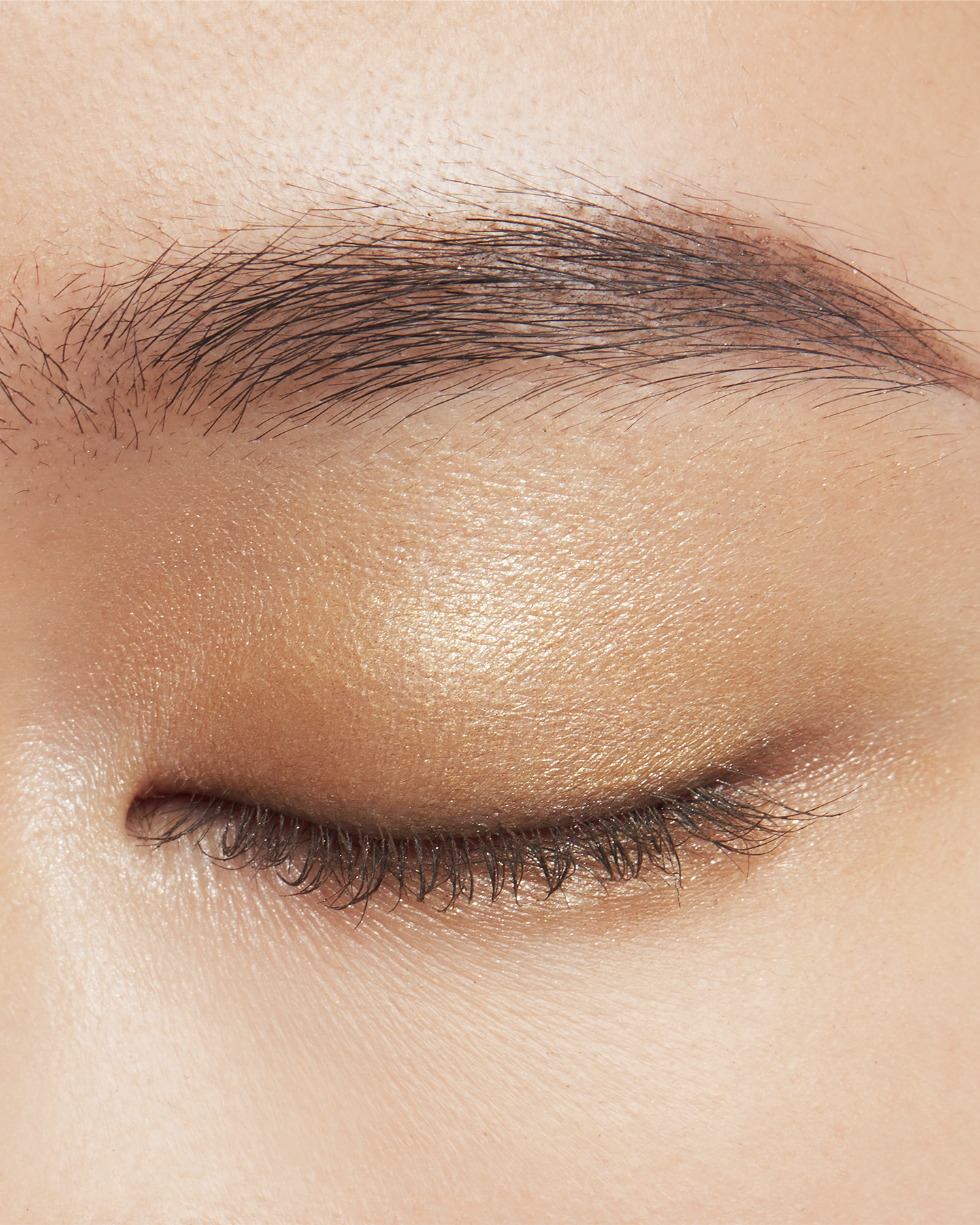 Photo of a medium skin tone model wearing EYE COLOR QUAD in 2-Beach Pebbles on the eyes.