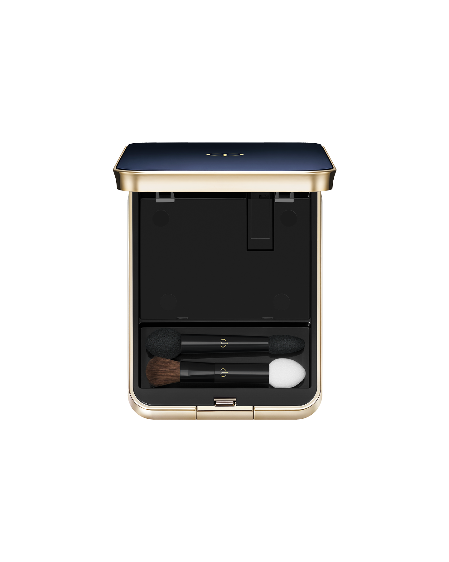 Photo of an exclusive case for "EYE COLOR QUAD" with the lid open. The blue-black lid features a gold trim. Inside, the top half has an empty compartment, while the bottom section holds two makeup applicators: a small brush and sponge-tip applicators.