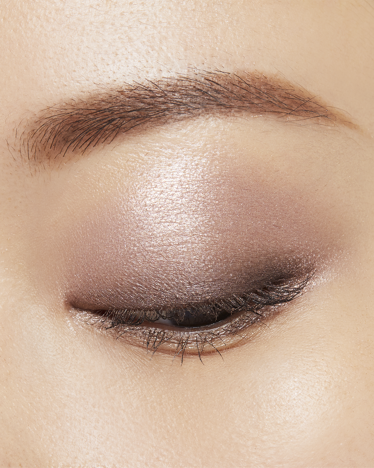 Photo of a medium skin tone model wearing EYE COLOR QUAD in 1-Sand Dunet on the eyes.