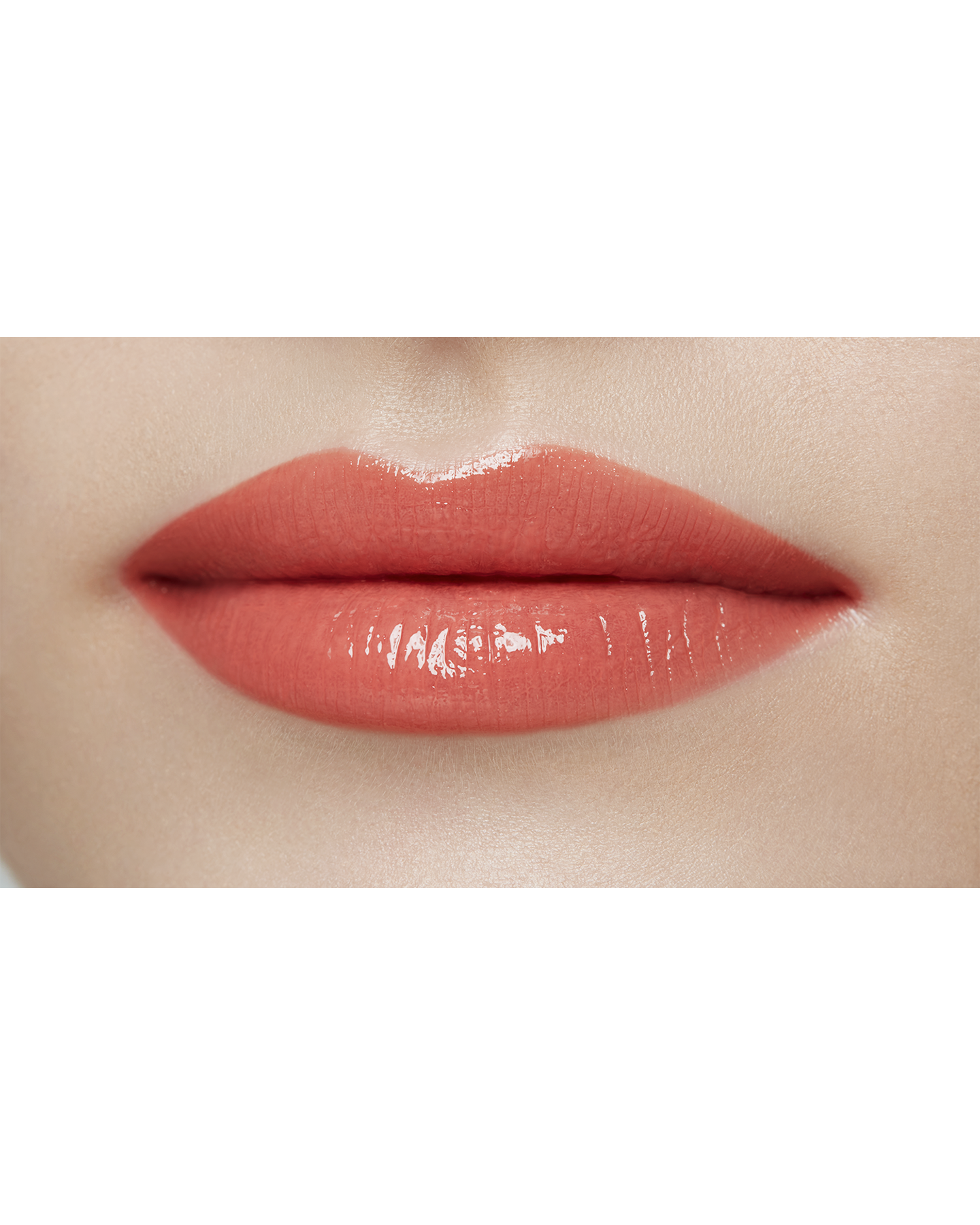 Photo of a light skin tone model  wearing  "LIPSTICK SHINE" in Red-Orange Rebel on the lips.