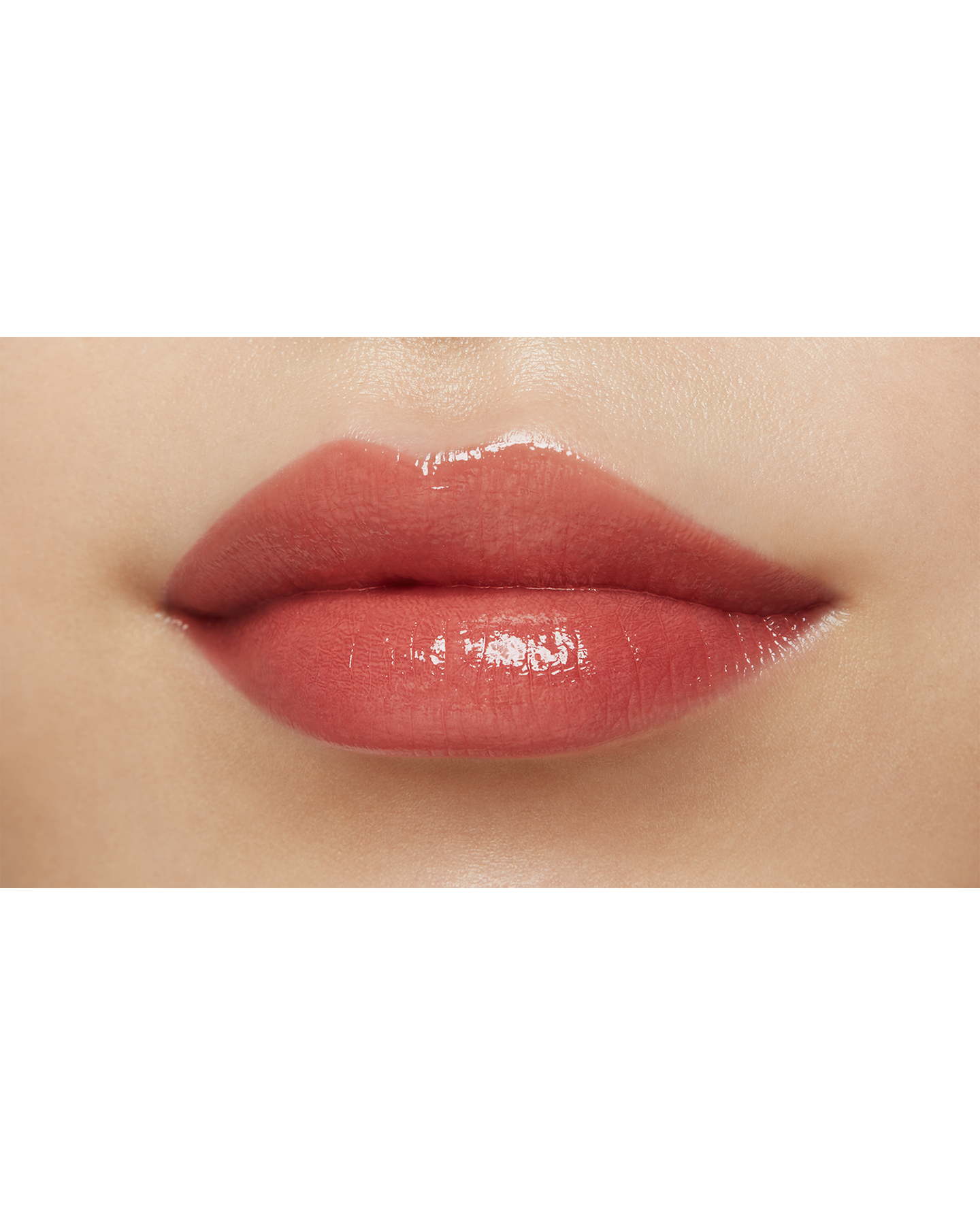 Photo of a medium skin tone model  wearing "LIPSTICK SHINE" in Red-Orange Rebel on the lips.
